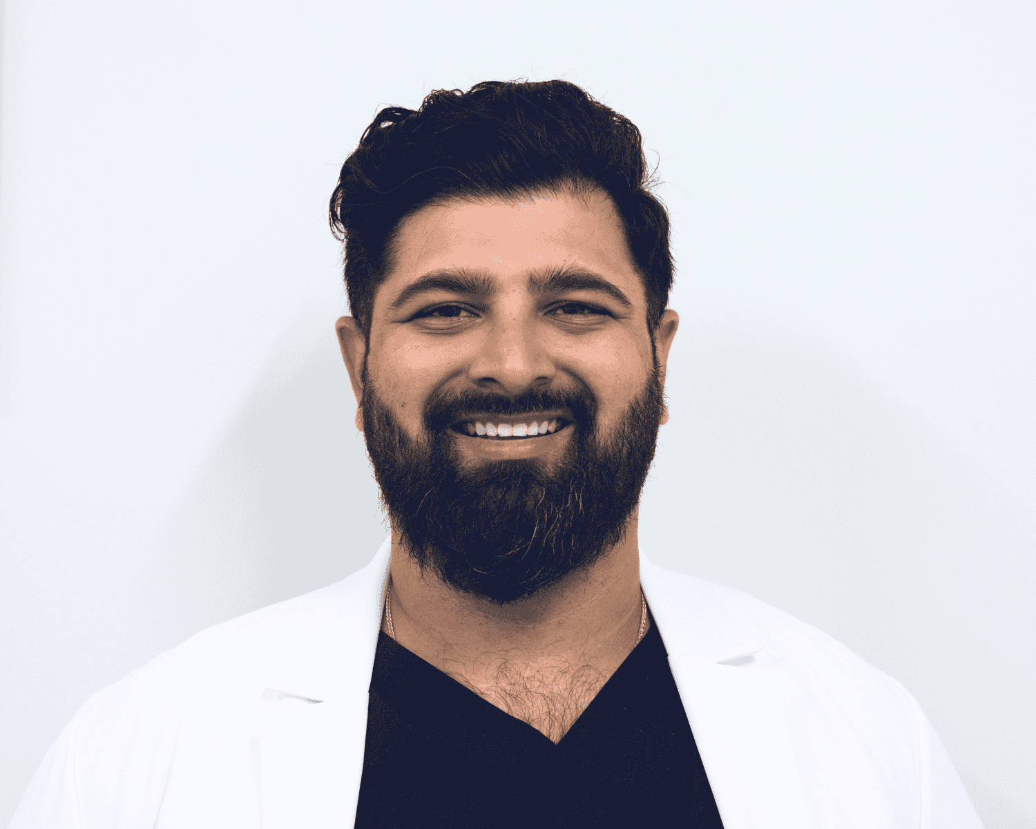 Smiling male dentist in white coat at Granada Dental Sherwood Park